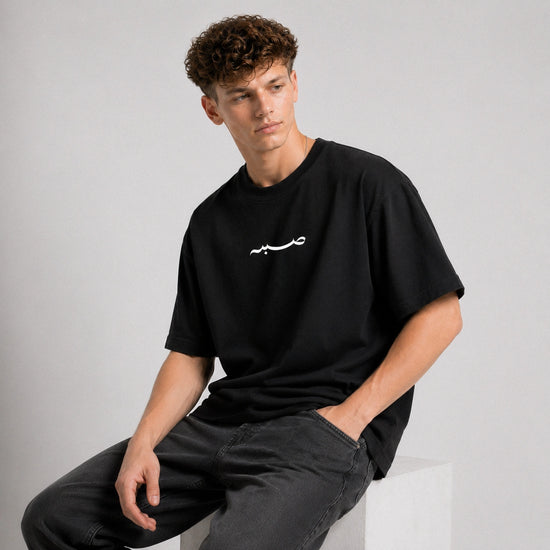 Person wearing a black t-shirt with white text on a gray background