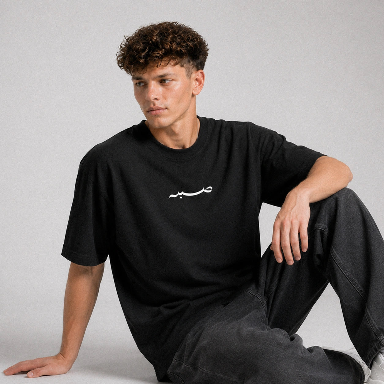 Person wearing a black t-shirt with white text on a gray background