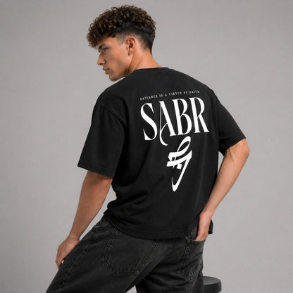 Person wearing a black t-shirt with 'SABR' printed on the back against a gray background