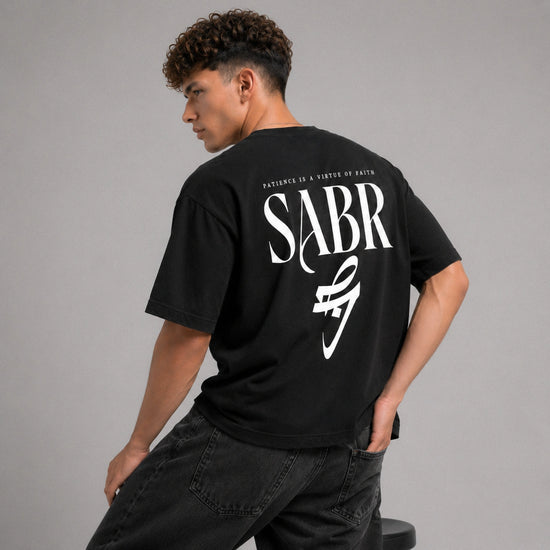 Person wearing a black t-shirt with 'SABR' printed on the back against a gray background
