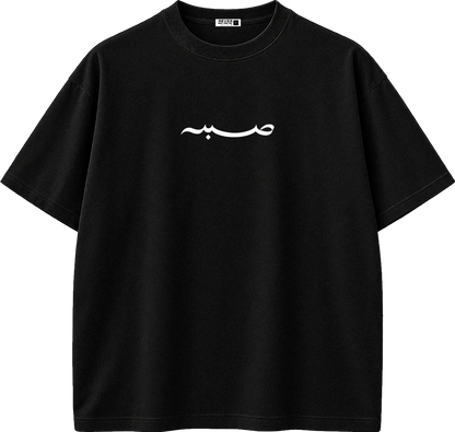 A black short-sleeve crewneck t-shirt with a white Arabic calligraphy graphic printed across the chest, displayed on a clean white background.