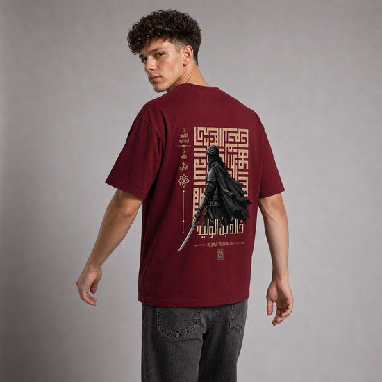 A man wearing a maroon short-sleeve graphic t-shirt, viewed from the back. The shirt features a large black and gold print of Darth Vader with a lightsaber and Arabic calligraphy.