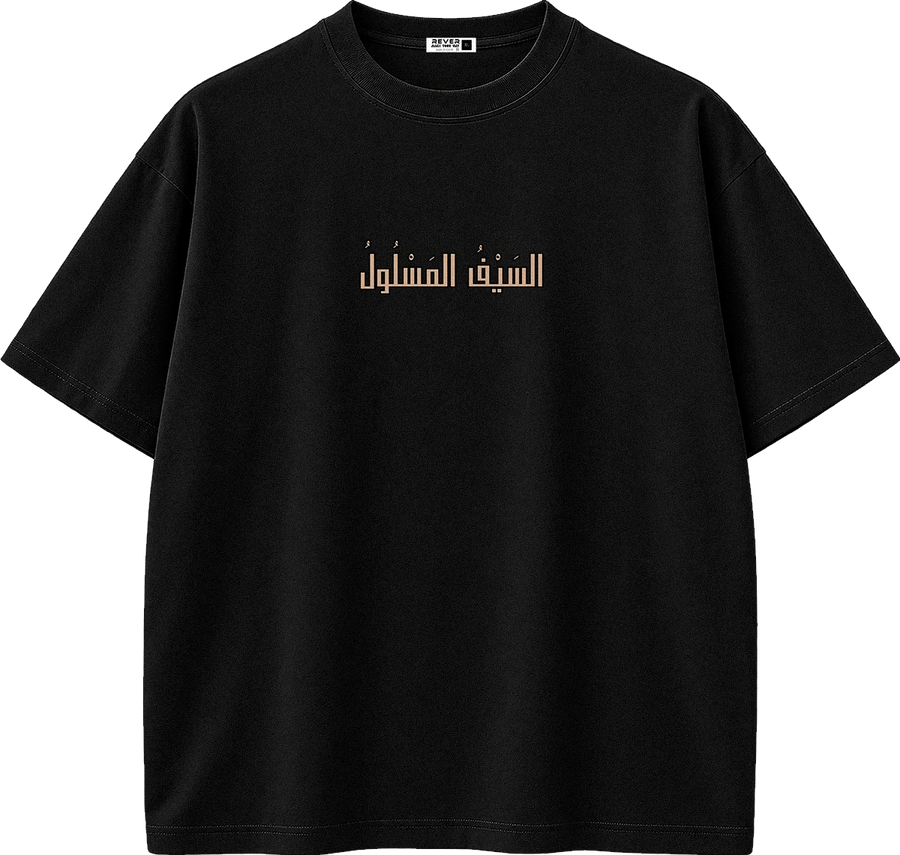A black short-sleeve crewneck t-shirt with a beige Arabic calligraphy graphic printed on the center chest, displayed on a clean white background.