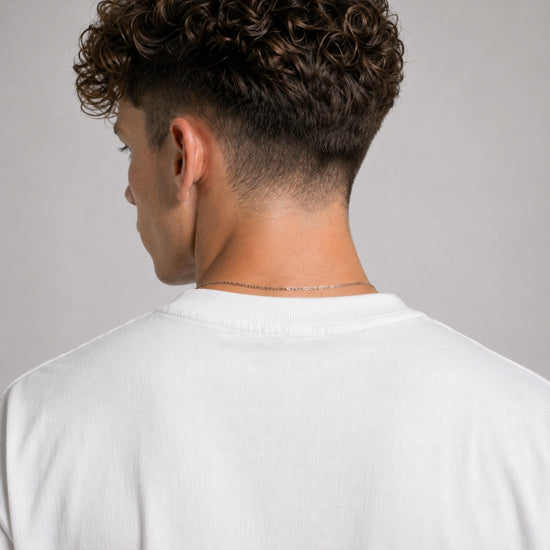 Person wearing a white shirt with a neutral background