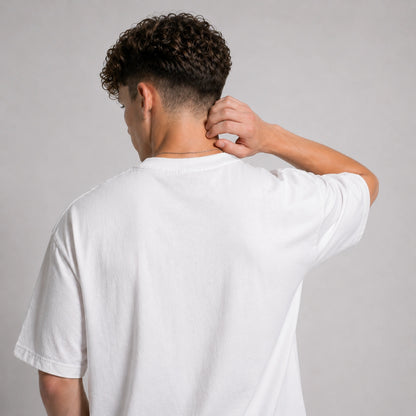 Person wearing a plain white t-shirt against a gray background