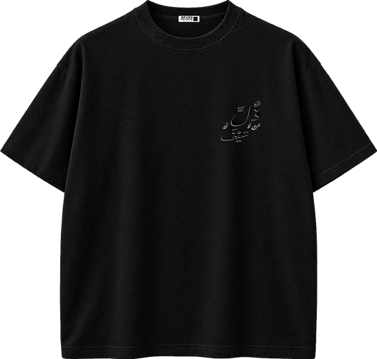 A black short-sleeve crewneck t-shirt with a small white Arabic calligraphy graphic on the left chest, displayed on a clean white background.