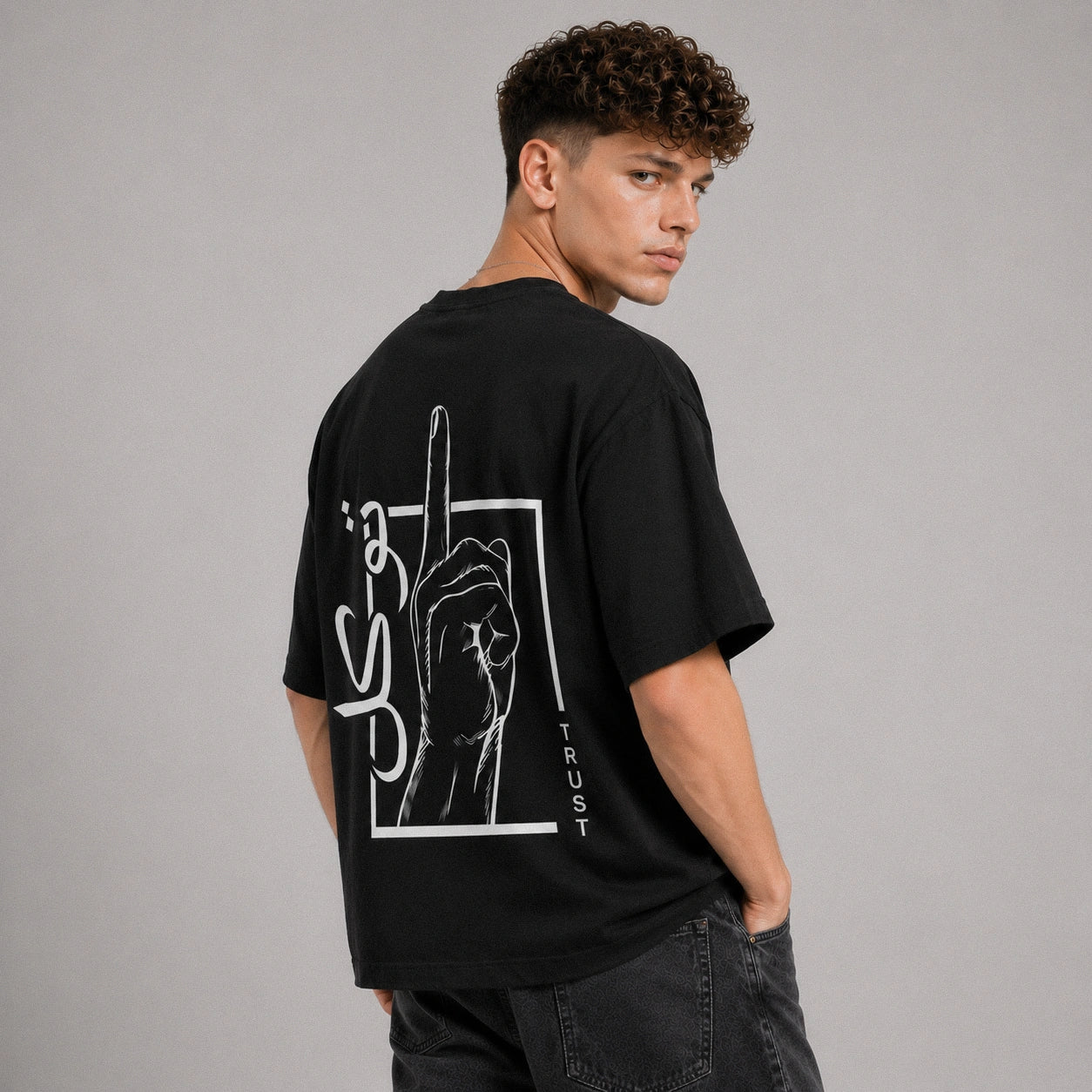 Person wearing a black t-shirt with a graphic design on the back against a gray background