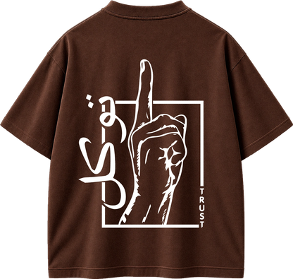 A brown short-sleeve t-shirt shown from the back, featuring a large white graphic print of a hand pointing upwards inside a square outline, with stylized lettering and the word 'TRUST' printed vertically.
