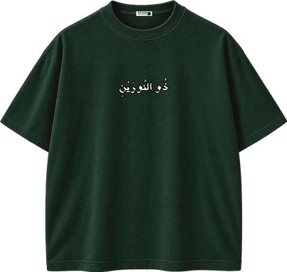 A dark forest green short-sleeve t-shirt with white Arabic text printed across the chest, displayed on a clean white background.