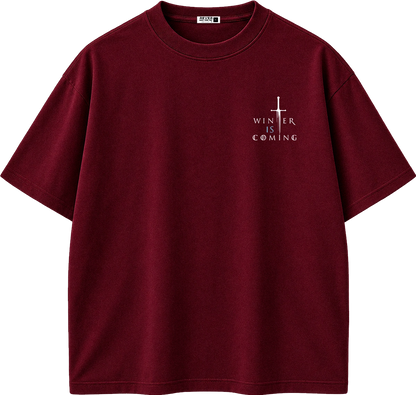 A dark red short-sleeve crewneck t-shirt with a small white graphic on the left chest featuring a cross and the text 'WINTER IS COMING'.