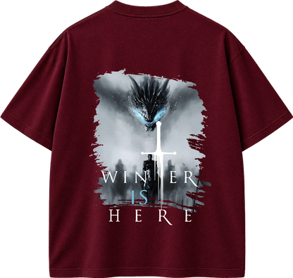 A maroon short-sleeve t-shirt shown from the back, featuring a large graphic print of a dragon, a white sword, and the text 'WINTER IS HERE' in white and light blue.