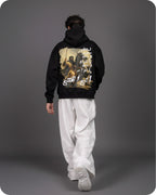 Person wearing a black hoodie with a graphic design on the back against a gray background