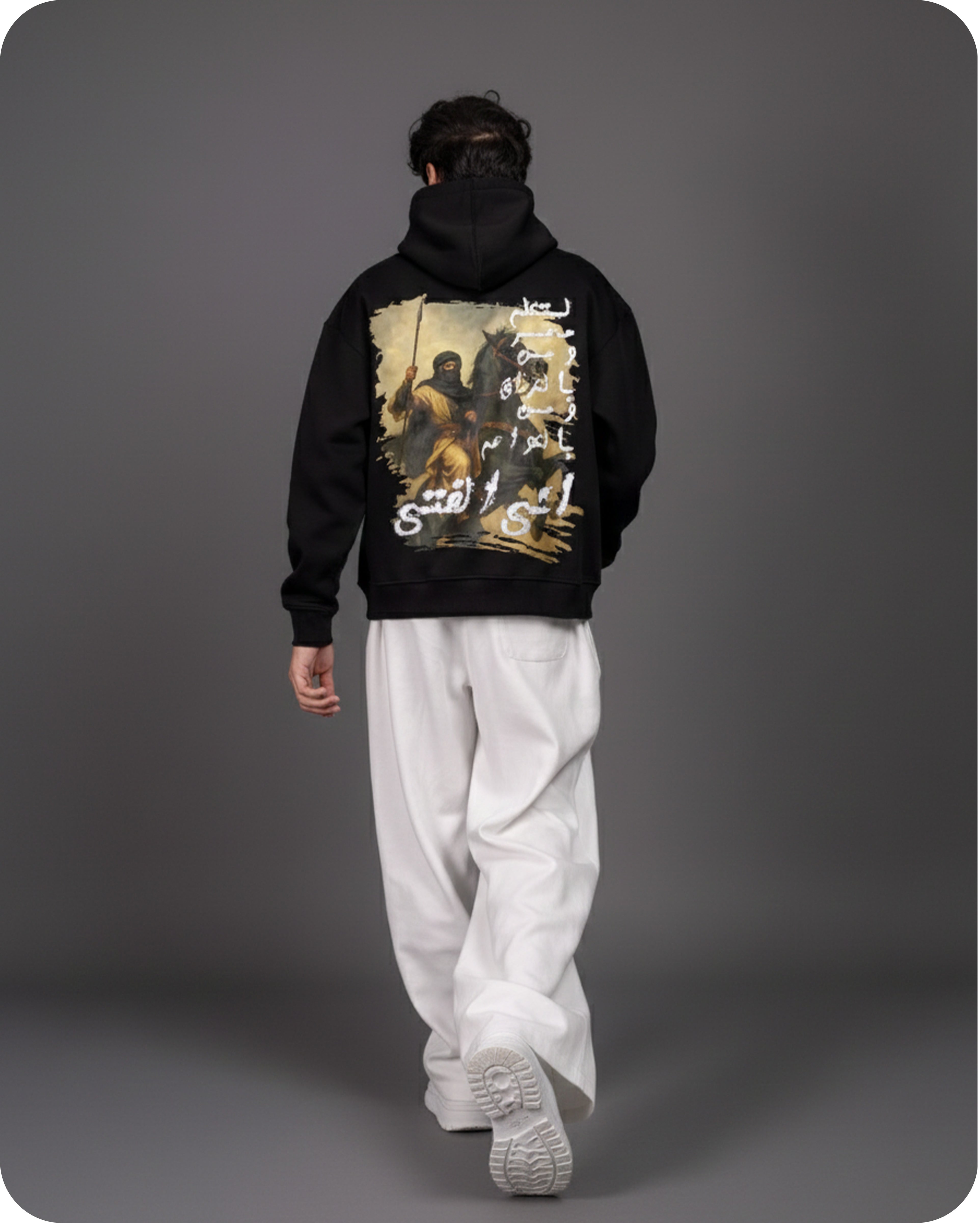 Person wearing a black hoodie with a graphic design on the back against a gray background