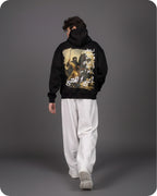 Person wearing a black hoodie with a graphic design on a gray background