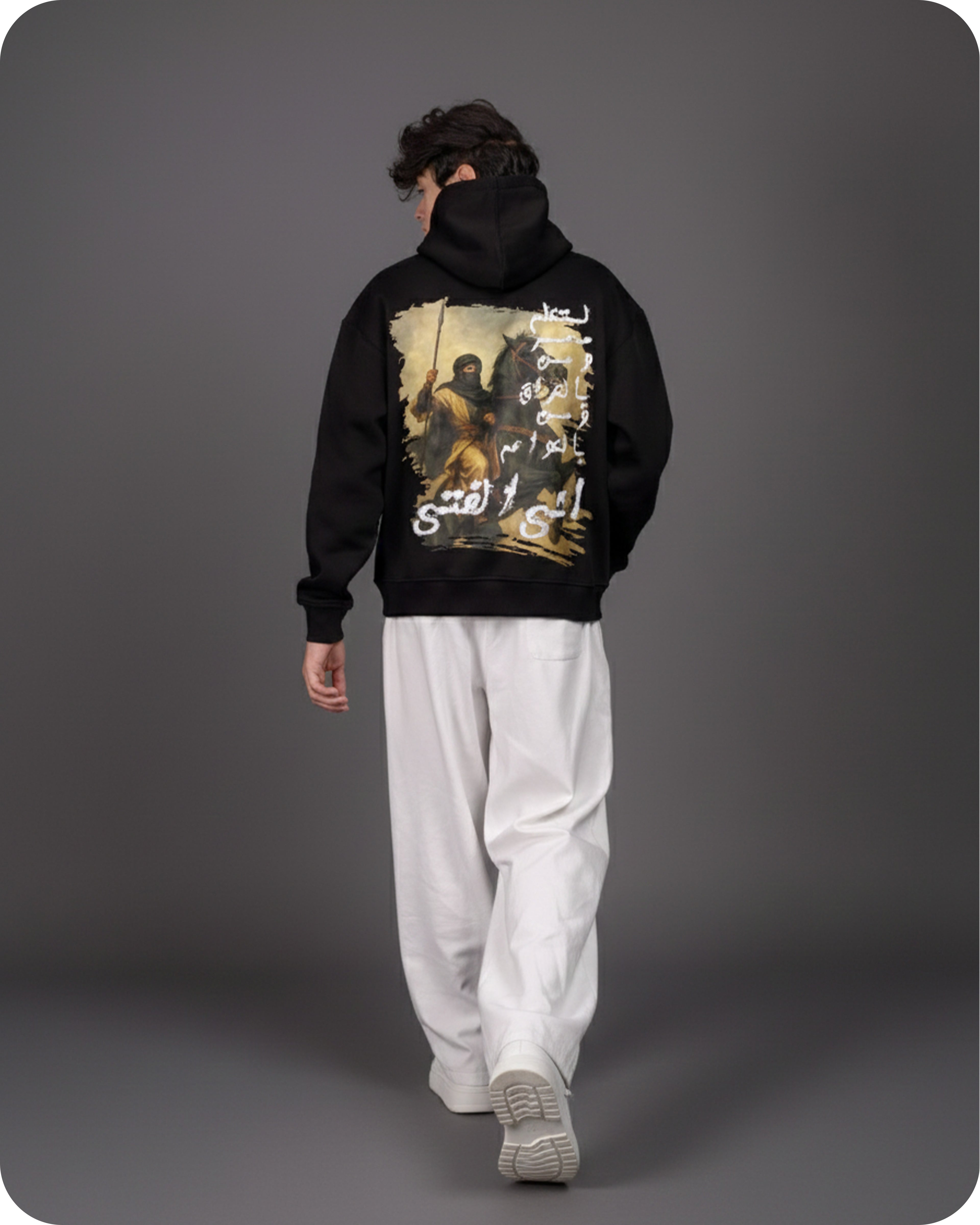 Person wearing a black hoodie with a graphic design on a gray background