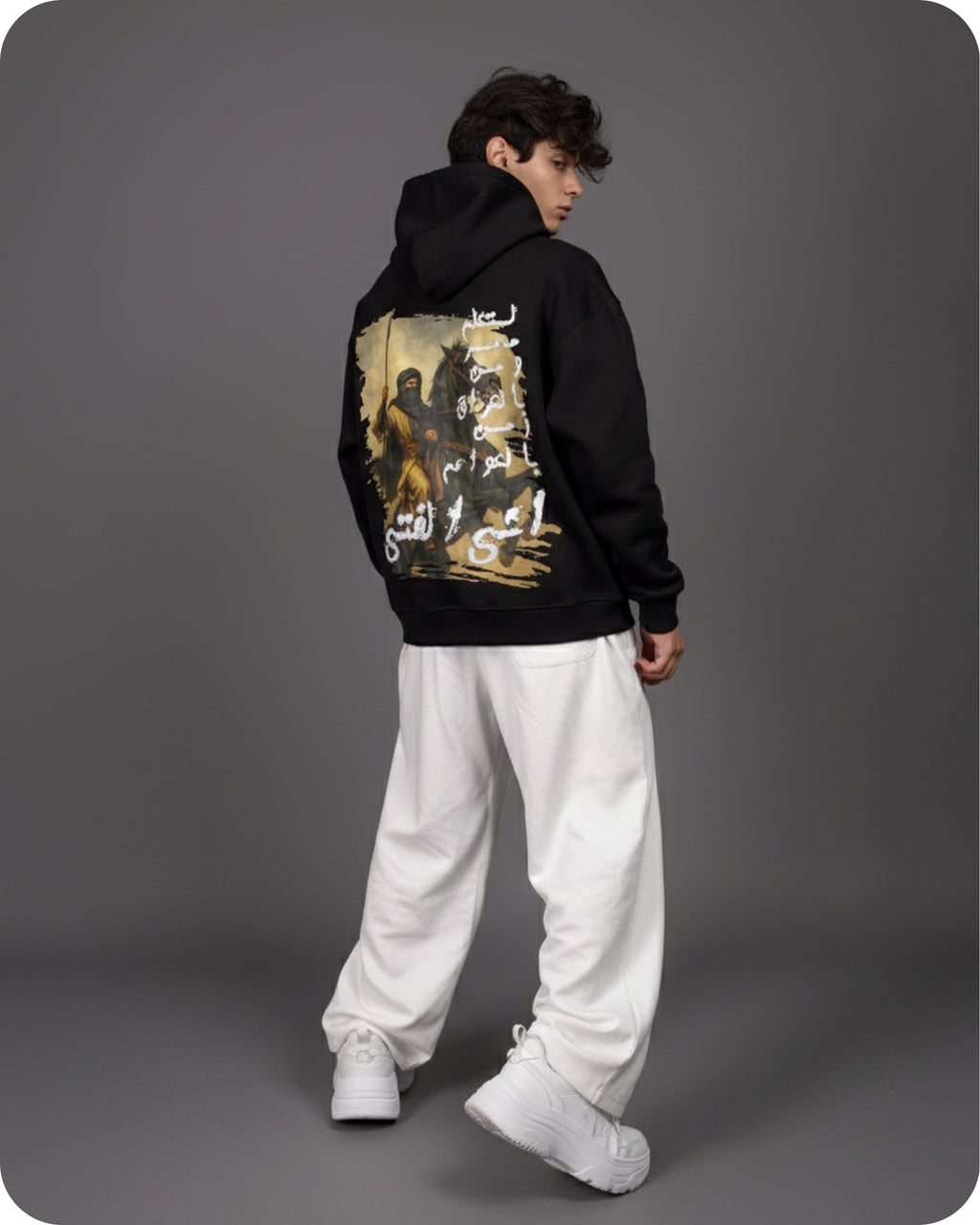 Person wearing a black hoodie with a graphic design on the back against a gray background