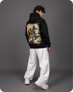 Person wearing a black hoodie with a graphic design on the back against a gray background