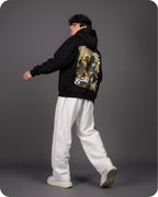 Person wearing a black hoodie with a graphic design on the back against a gray background