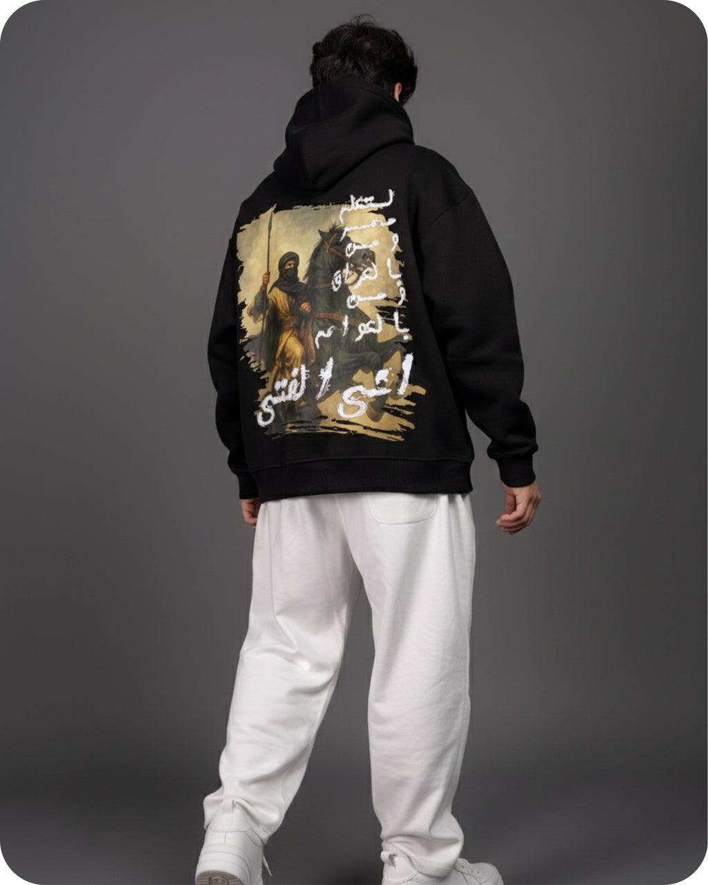 Person wearing a black hoodie with a graphic design on the back against a gray background