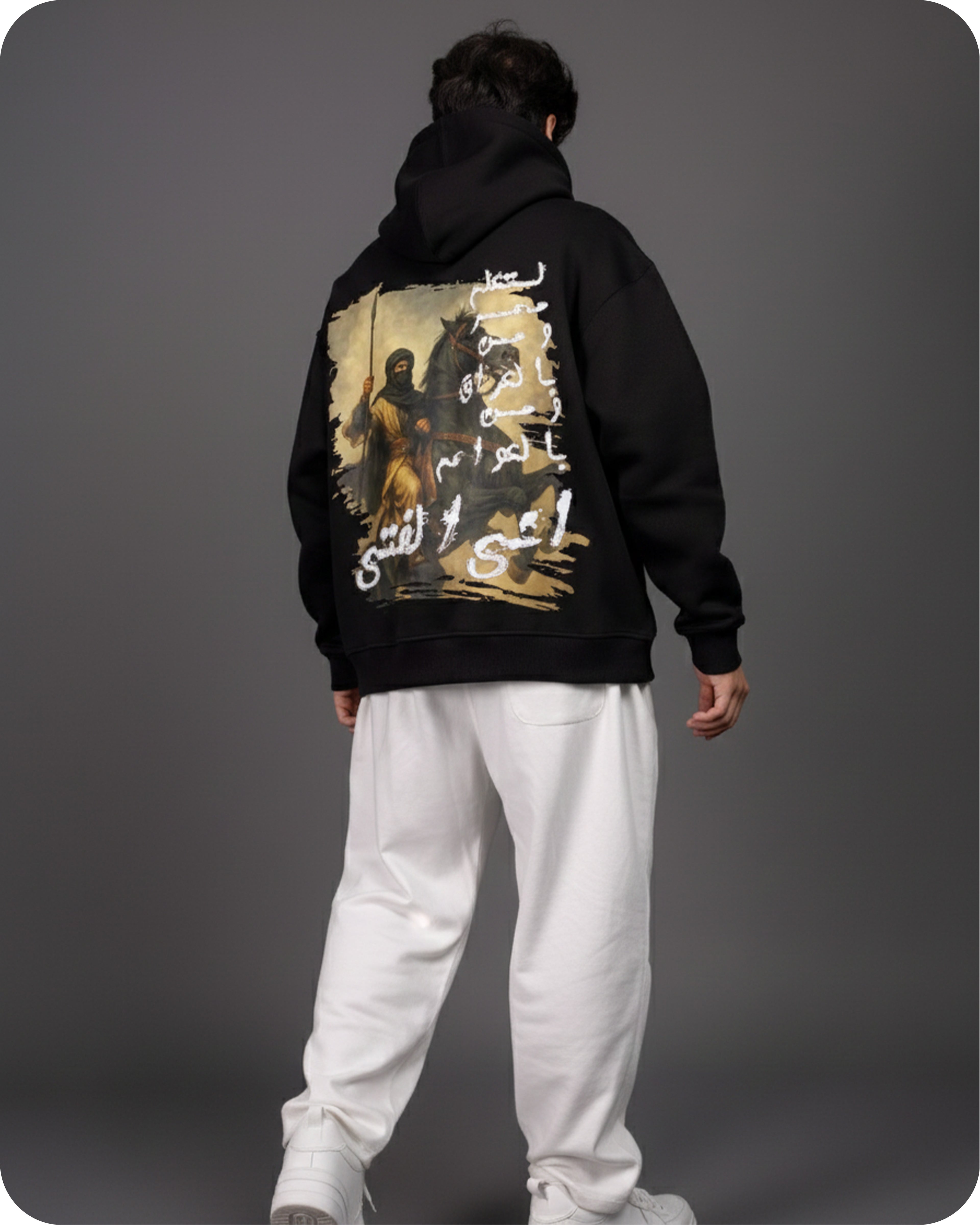 Person wearing a black hoodie with a graphic design on the back against a gray background