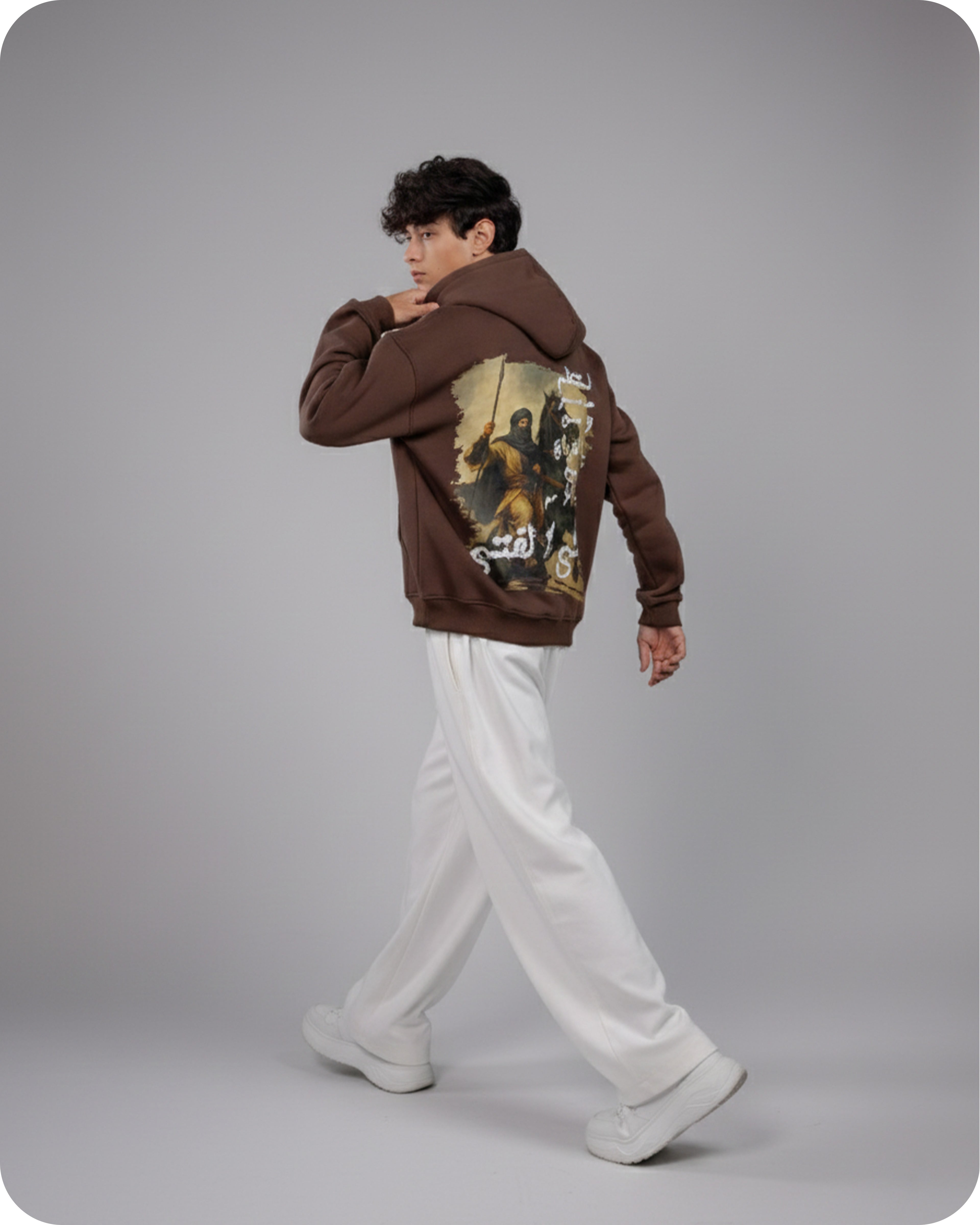 Person wearing a brown hoodie with a graphic design on a gray background