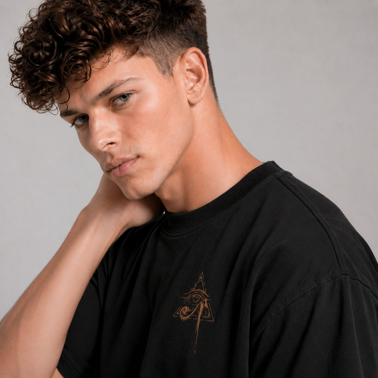 Man wearing a black t-shirt with a logo on a gray background