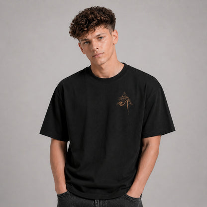 Person wearing a black t-shirt with a small design on a gray background