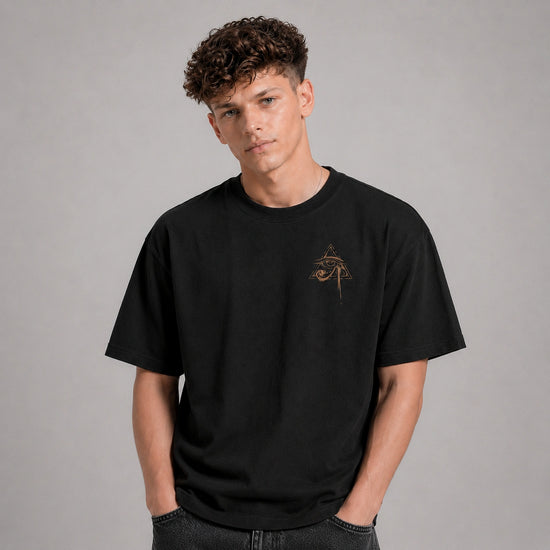 Person wearing a black t-shirt with a small design on a gray background