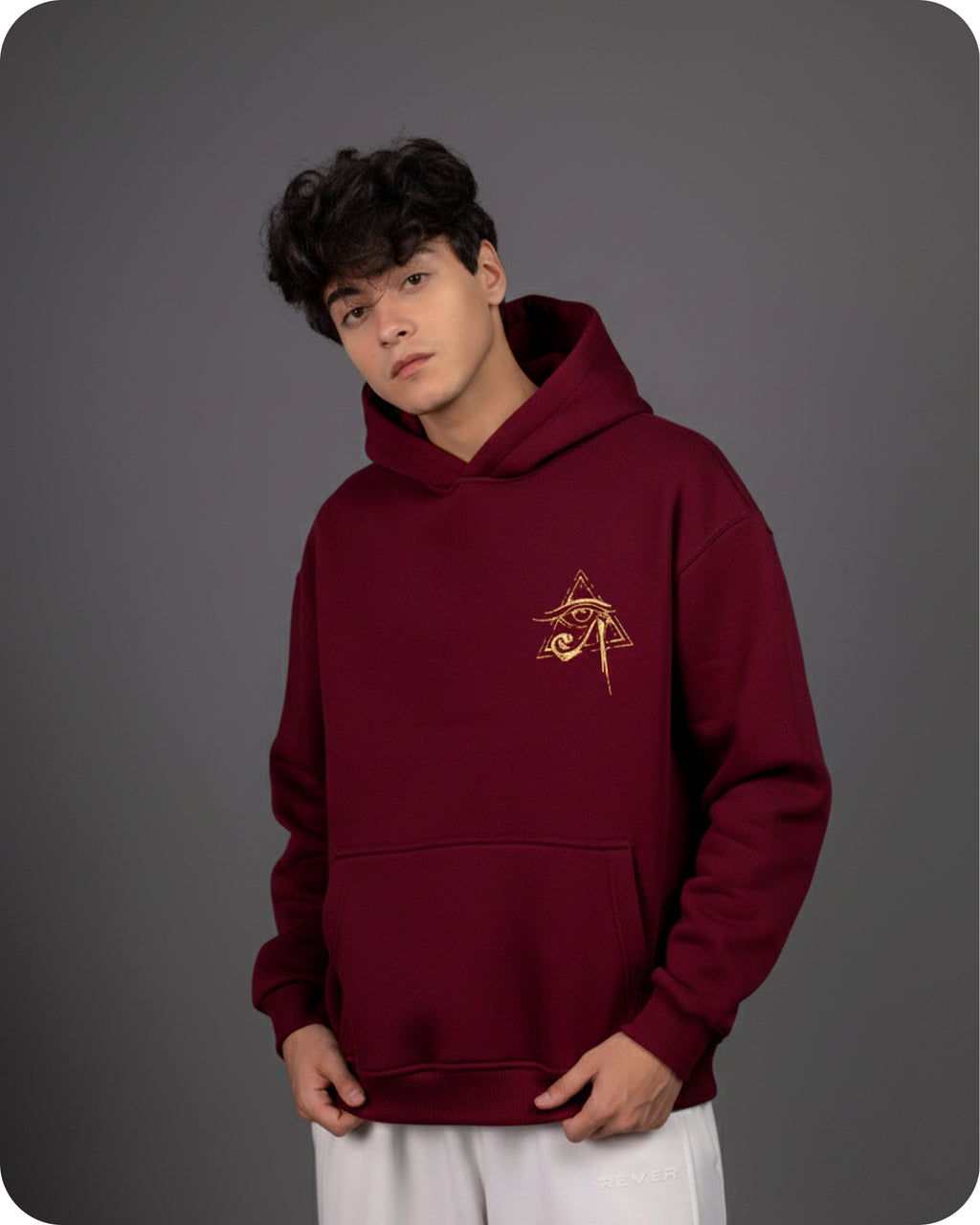 Person wearing a maroon hoodie with a logo on a gray background