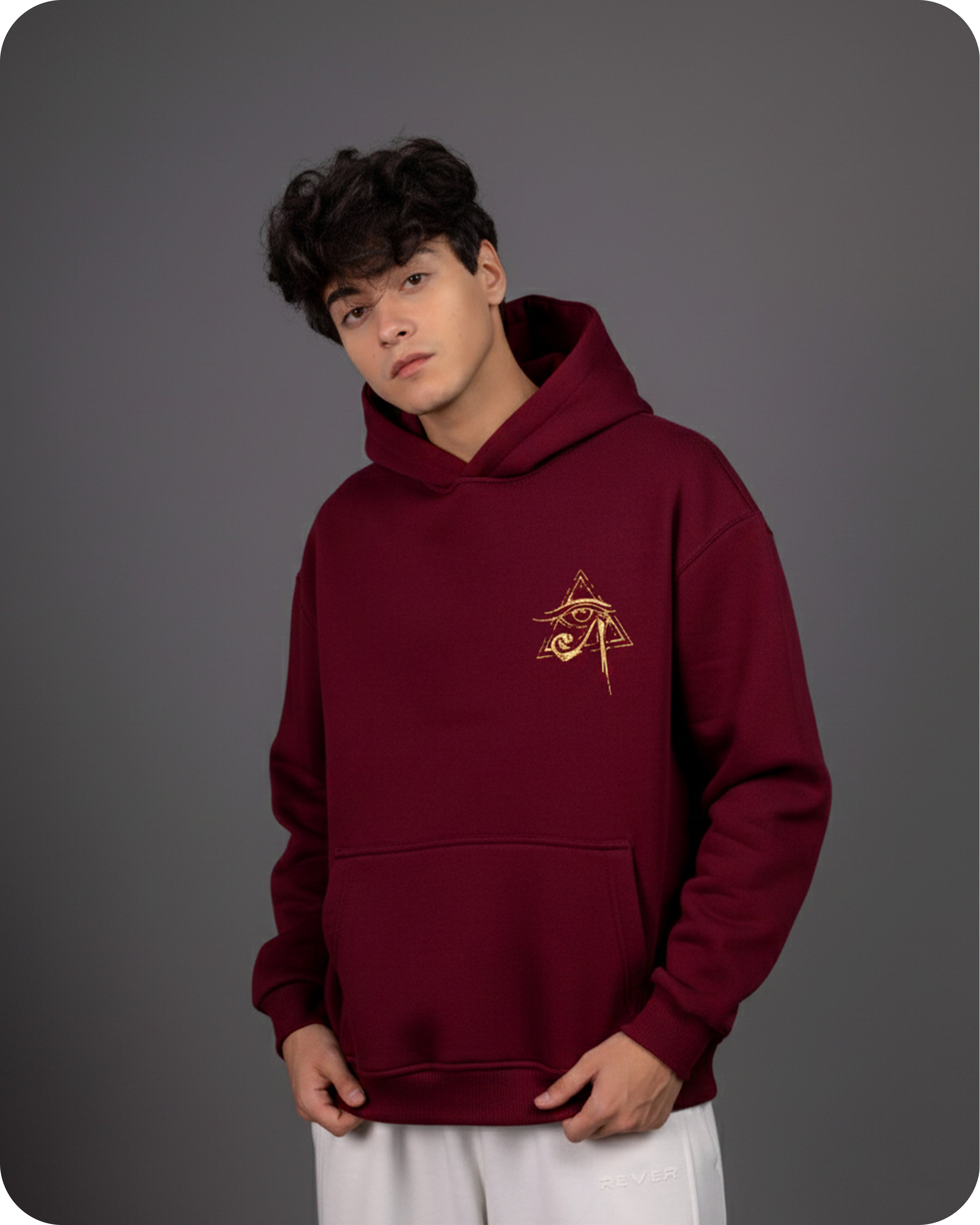 Person wearing a maroon hoodie with a logo on a gray background