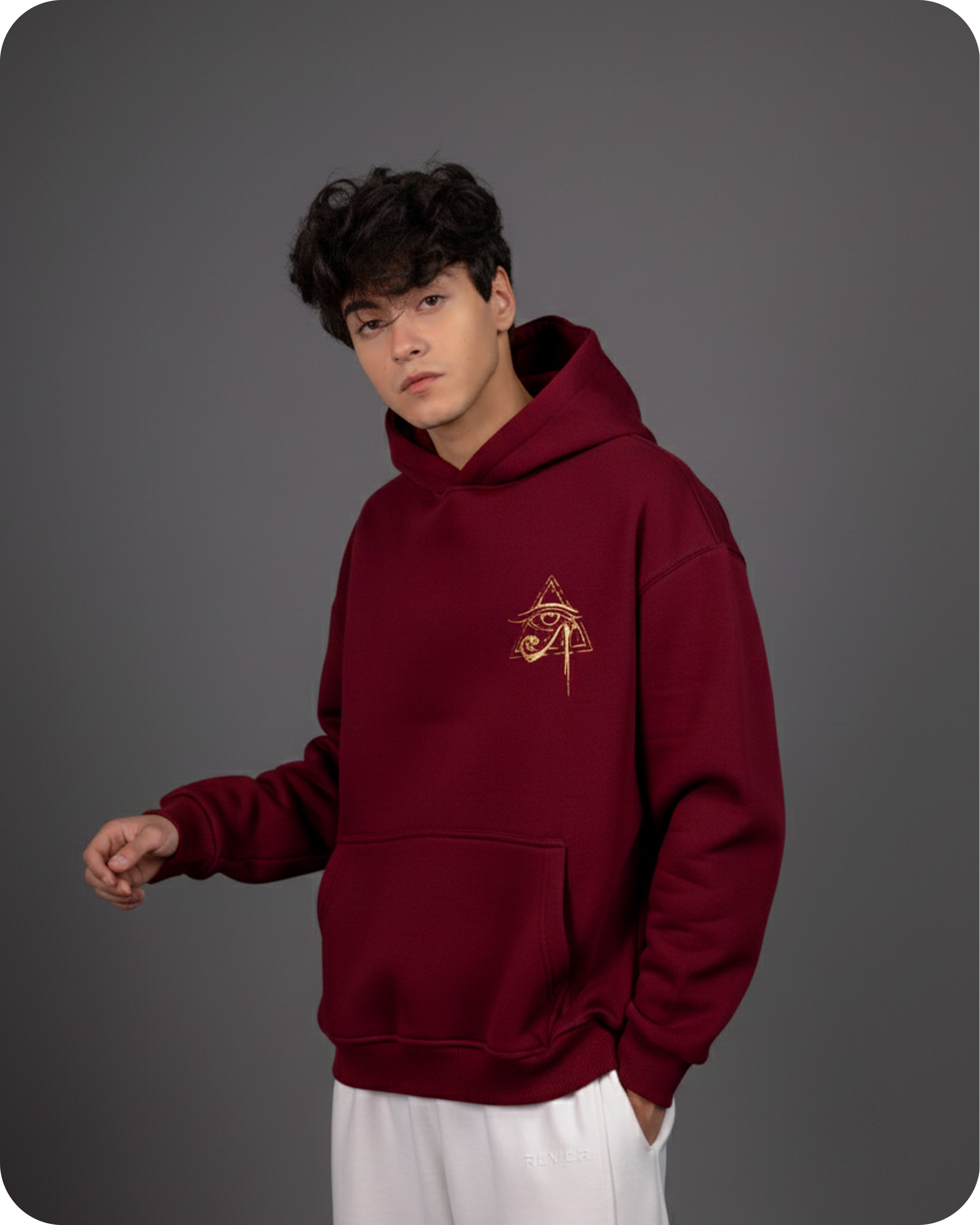 Person wearing a maroon hoodie with a logo on a gray background