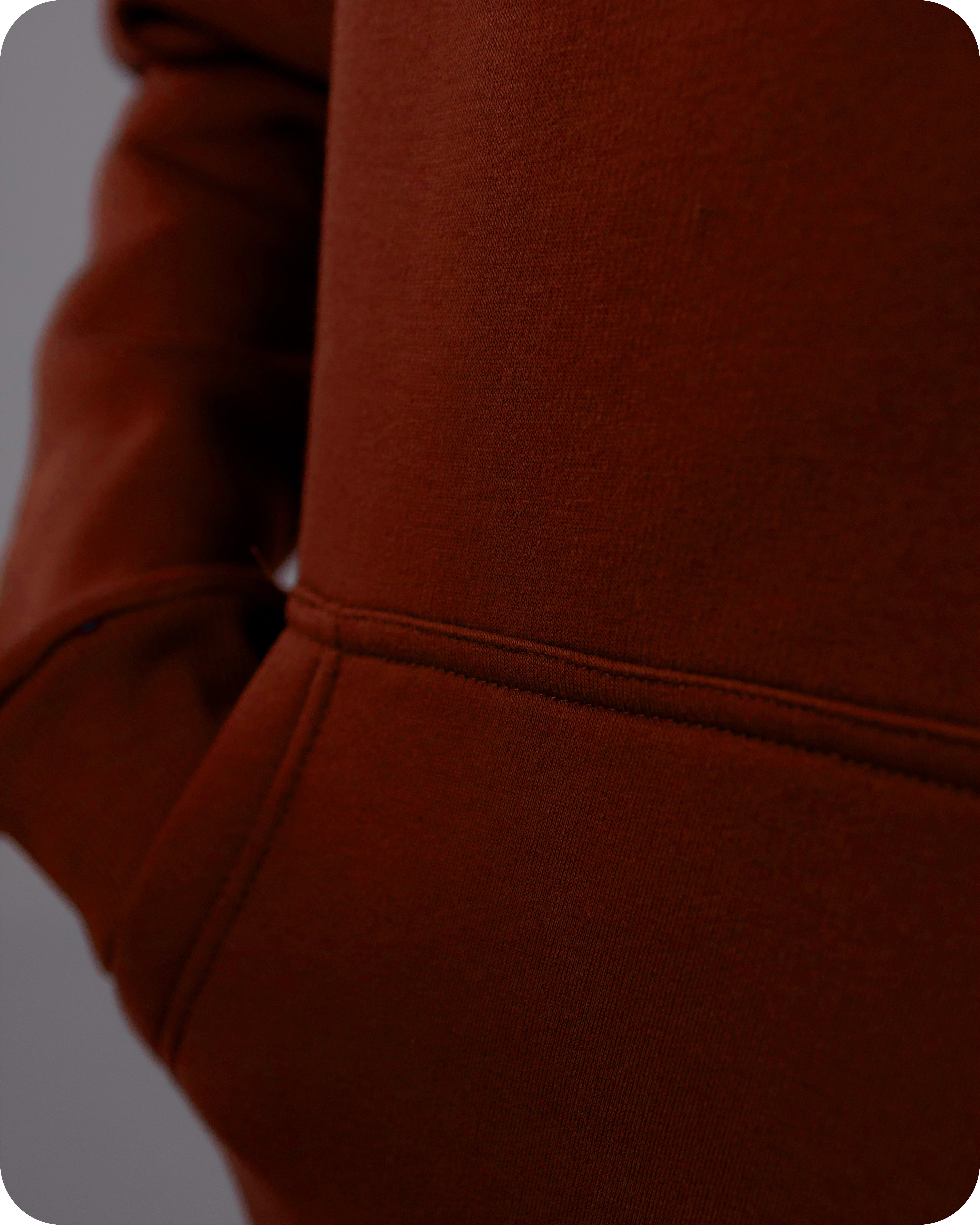 Close-up of a brown hoodie with a focus on the sleeve and fabric texture.