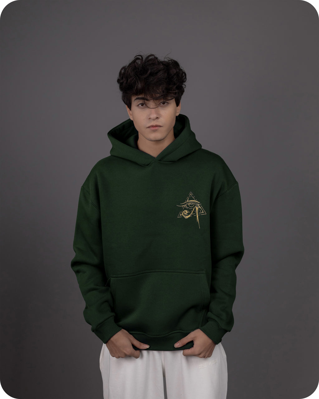 Person wearing a green hoodie with a logo on a gray background