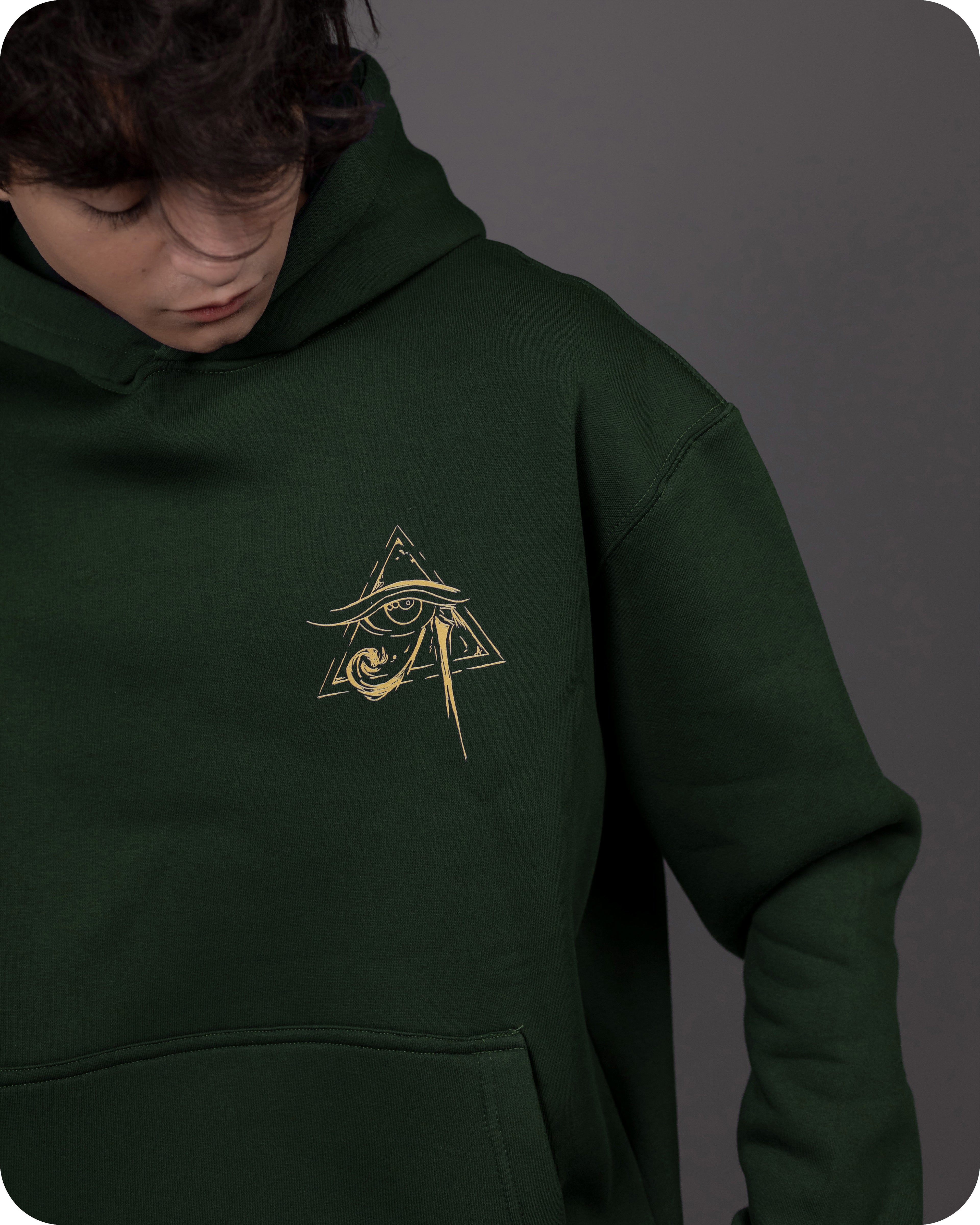 Person wearing a green hoodie with a gold embroidered symbol on a gray background
