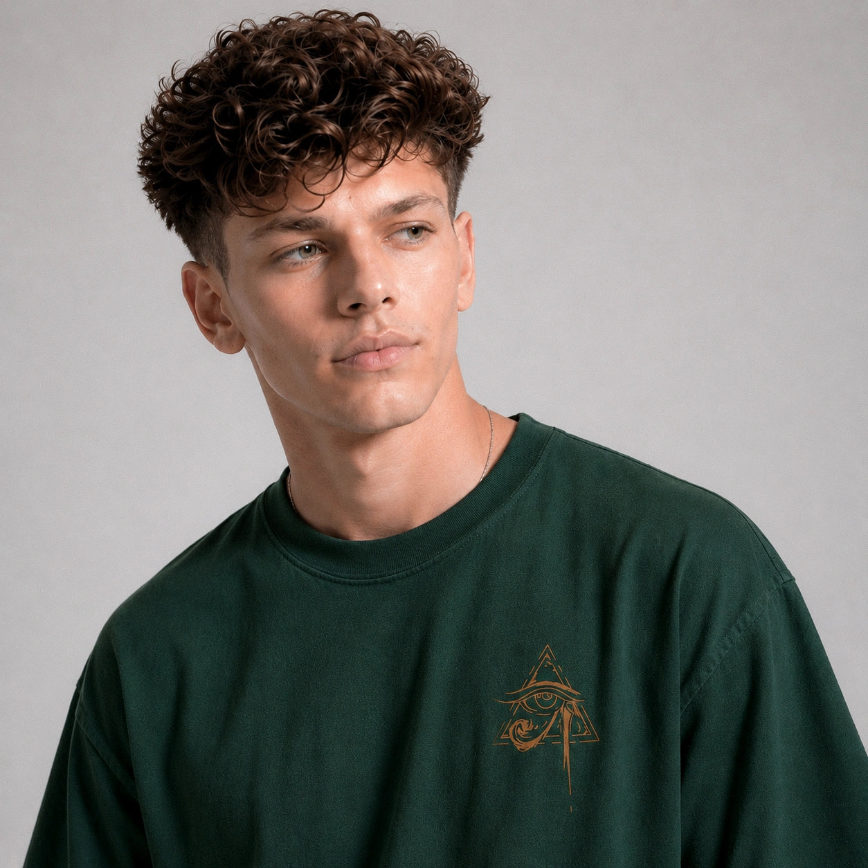 Man wearing a green sweatshirt with a logo on a gray background
