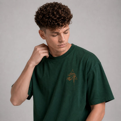 Man wearing a green t-shirt with a small logo on a gray background