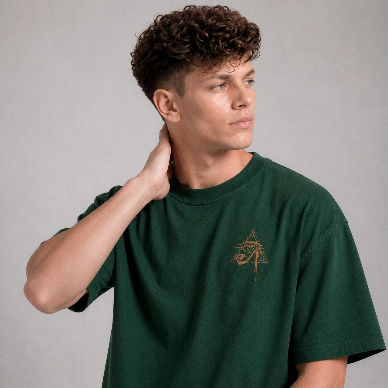 Man wearing a green t-shirt with a logo on a gray background