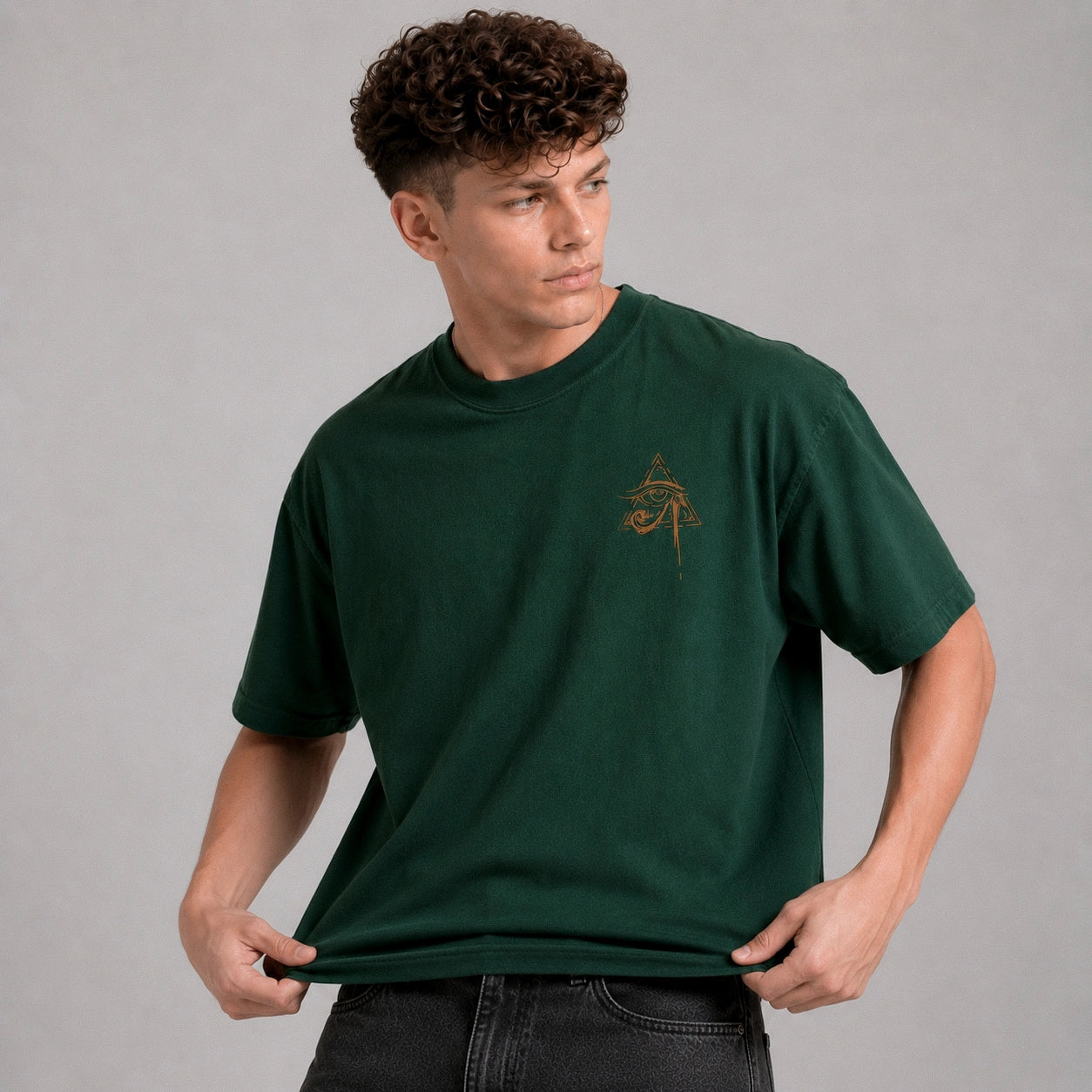 Man wearing a green t-shirt with a small logo on a gray background
