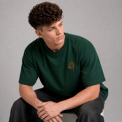 Man wearing a green t-shirt with a logo sitting against a gray background