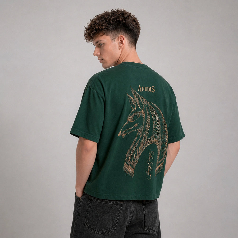 Person wearing a green t-shirt with a horse design on the back against a gray background