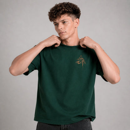 Man wearing a green t-shirt with a logo on a gray background