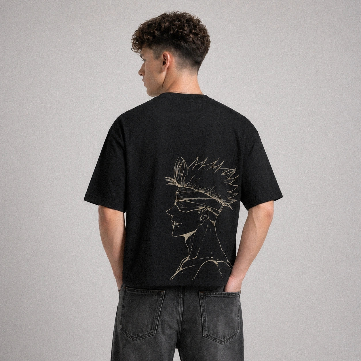 Person wearing a black t-shirt with a design on the back against a gray background