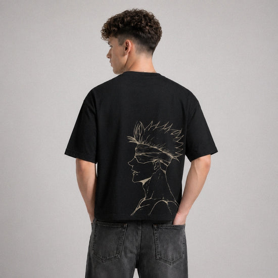Person wearing a black t-shirt with a design on the back against a gray background