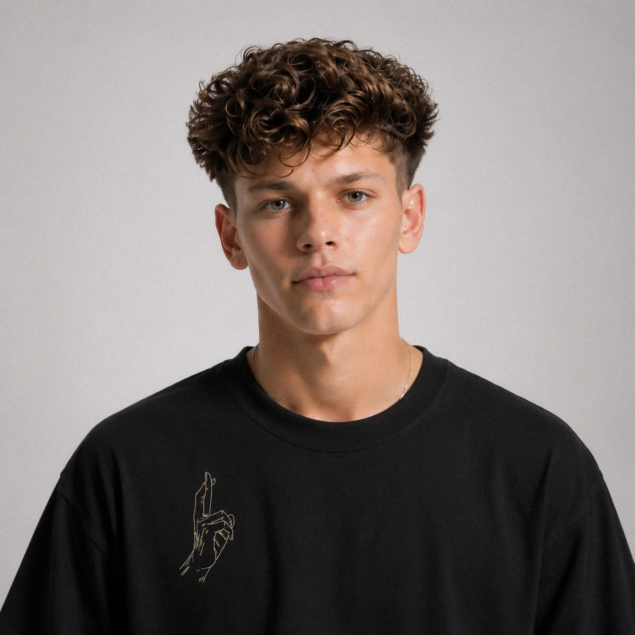 Man wearing a black sweatshirt with a small design on a plain background