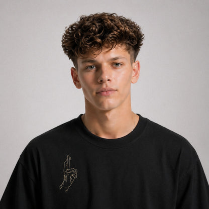Man wearing a black sweatshirt with a small design on a plain background