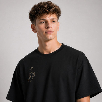 Man wearing a black t-shirt with a small design on a gray background
