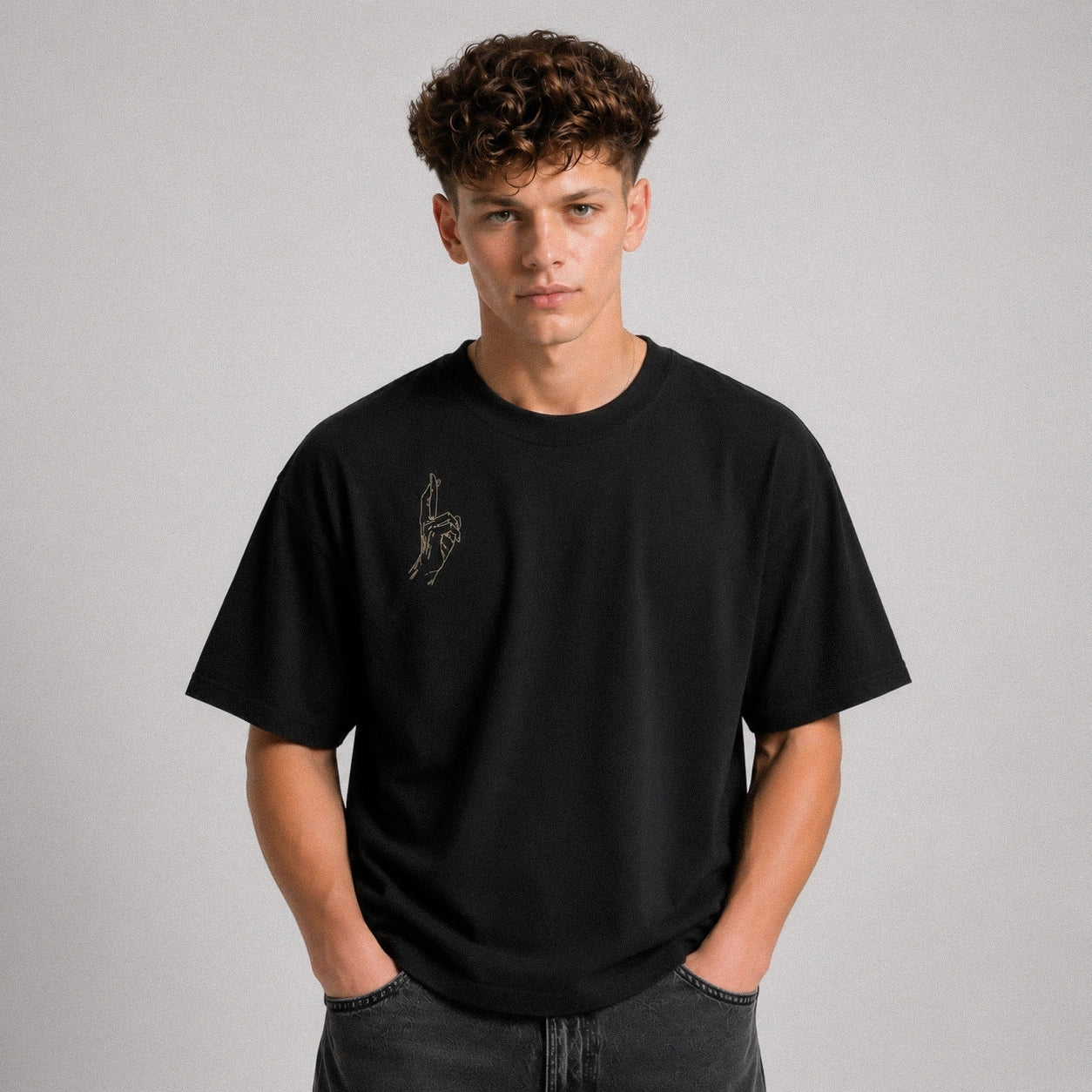 Person wearing a black t-shirt with a logo on a gray background