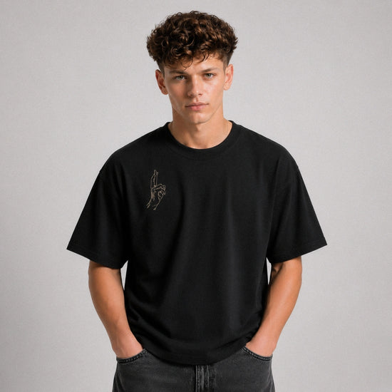 Person wearing a black t-shirt with a logo on a gray background