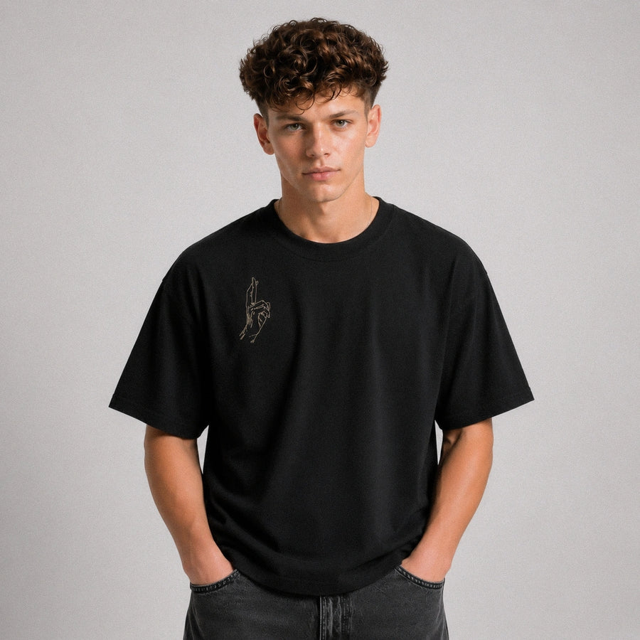 Person wearing a black t-shirt with a logo on a gray background