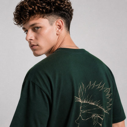 Person wearing a green t-shirt with a design on the back against a gray background